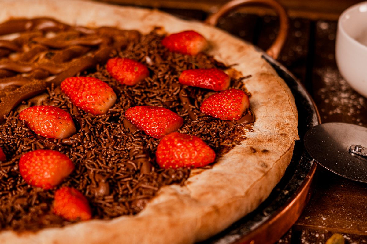 Pizza doce de chocolate com granulado e morangos